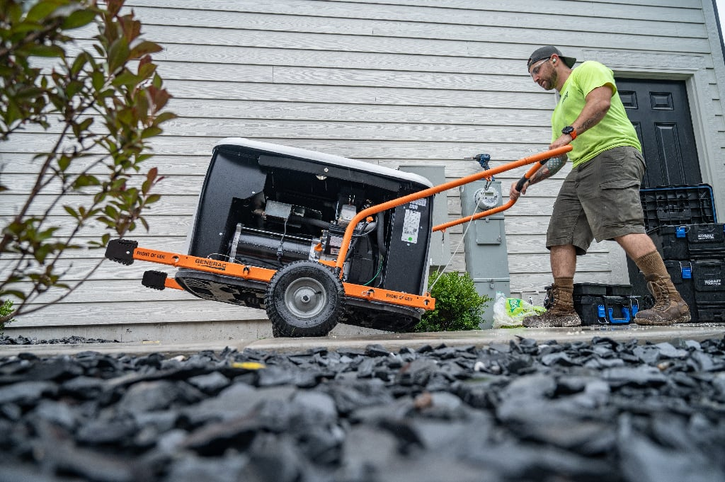 Installers moving a Generac standby generator into position