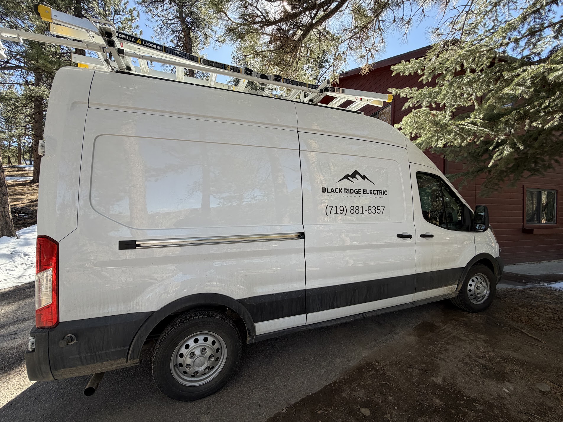 Black Ridge Electric service van with roof ladders beside a home