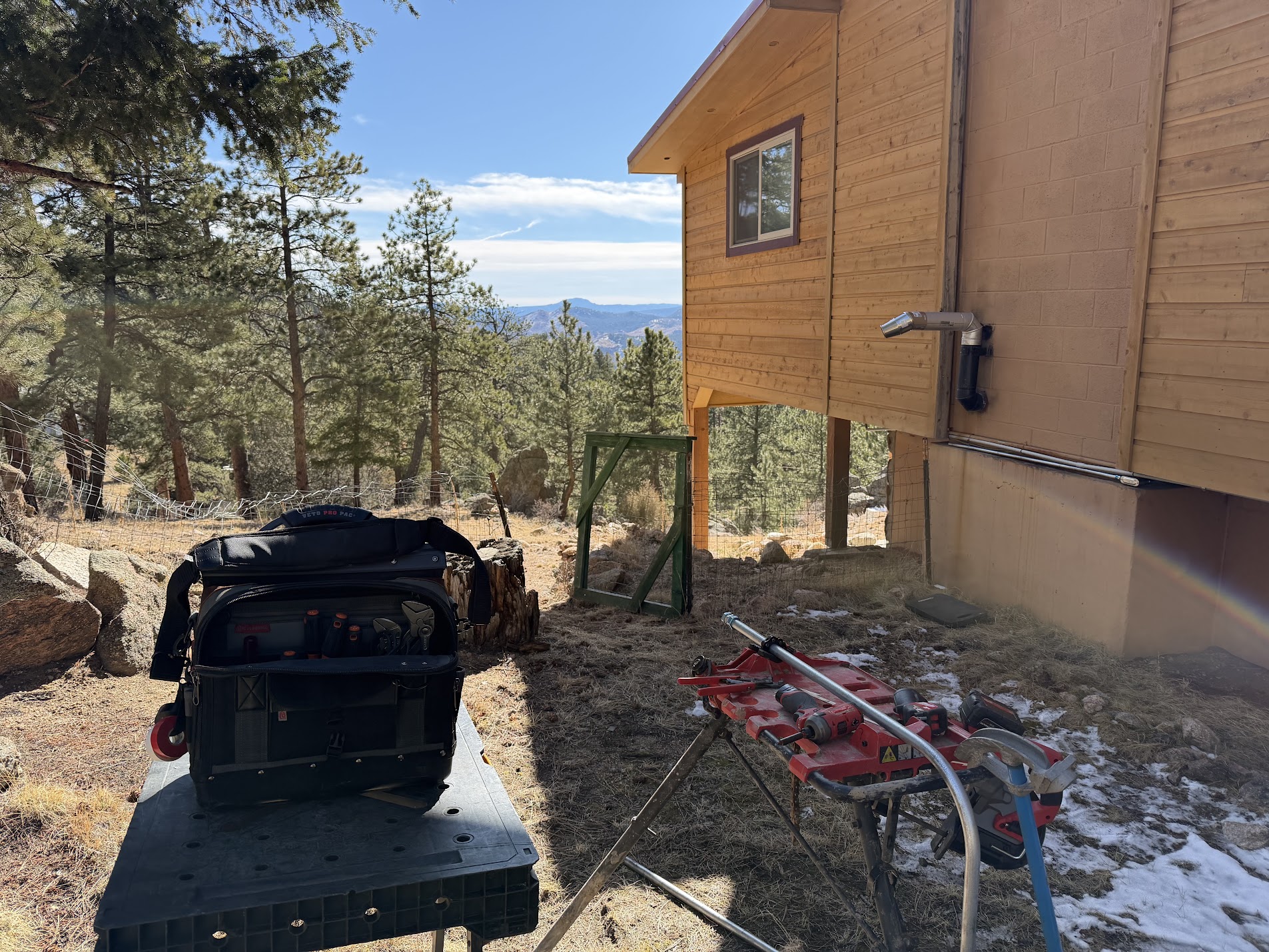 Electrical conduit installed along a home exterior with tools nearby