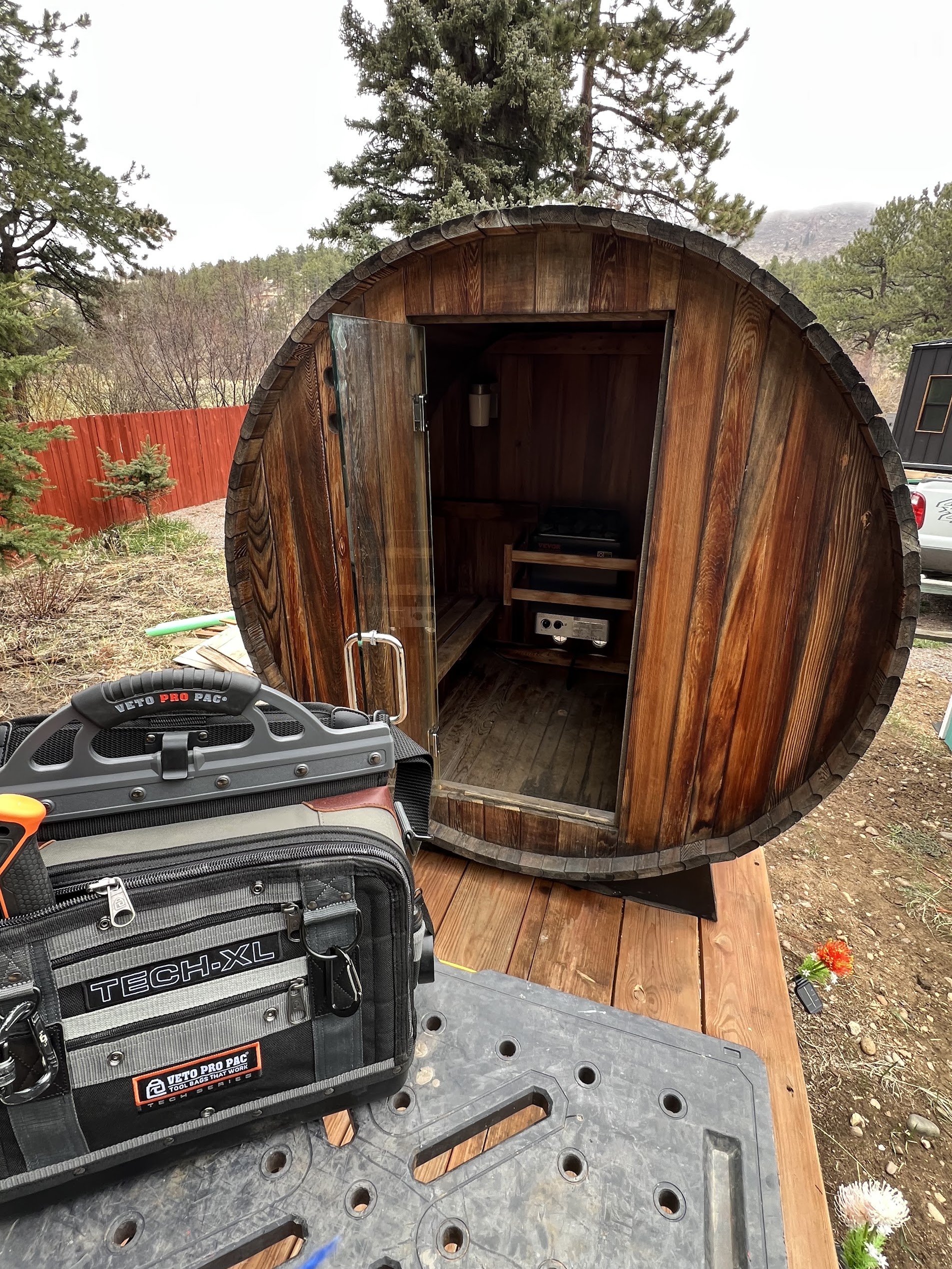 Outdoor barrel sauna with electrical tools beside the entrance