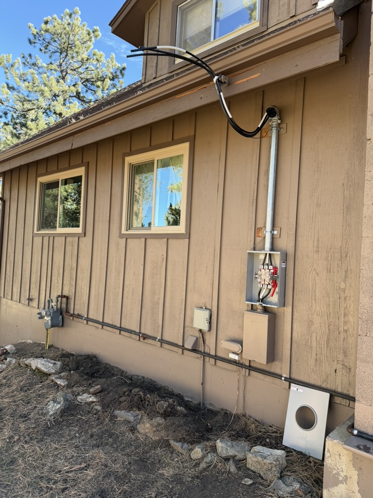 Meter socket and service mast mounted on a home exterior during electrical work