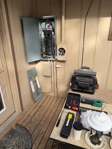 Open electrical panel with torque tools and equipment arranged nearby