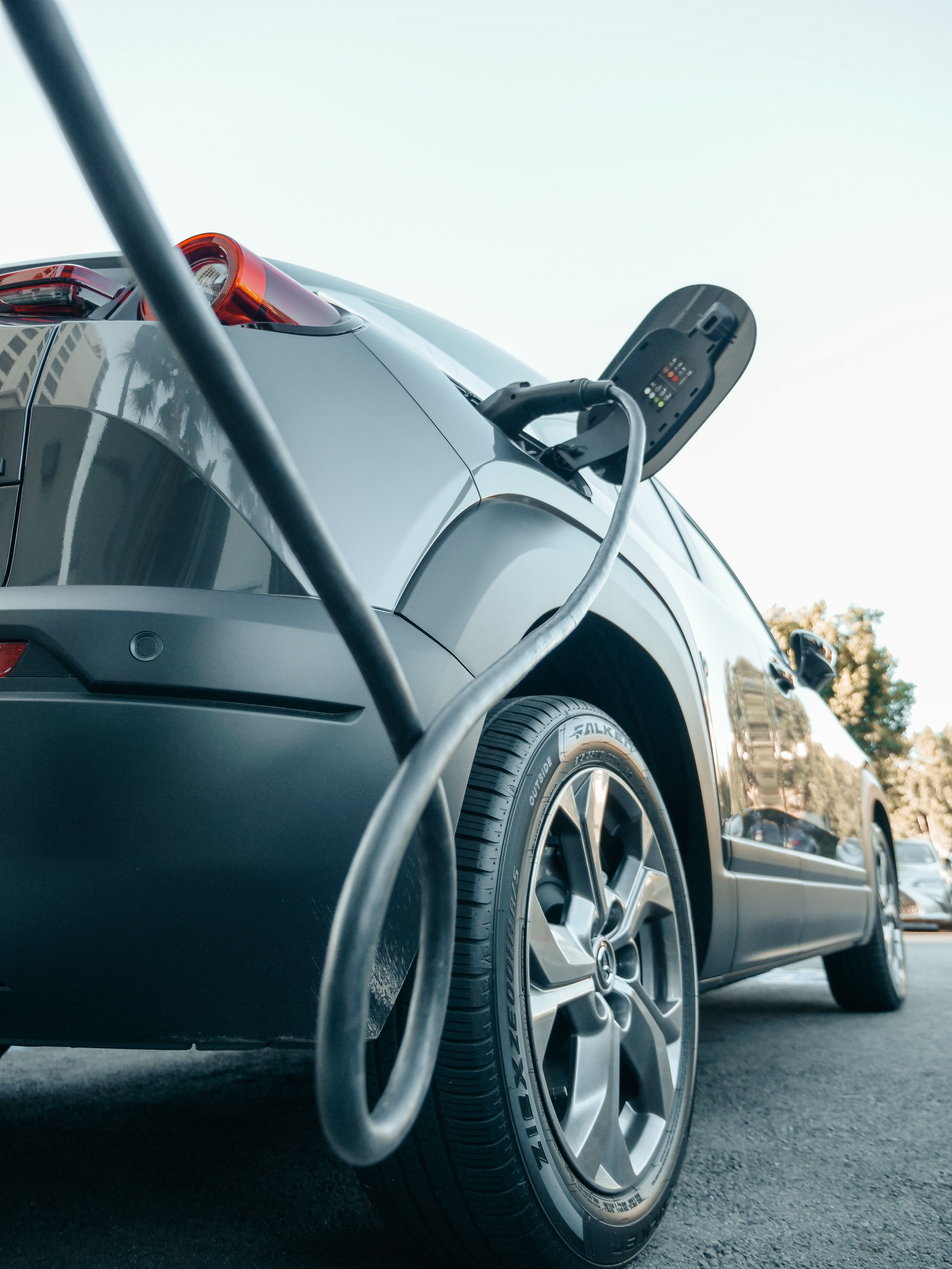 Charging cable connected to an electric vehicle outdoors.