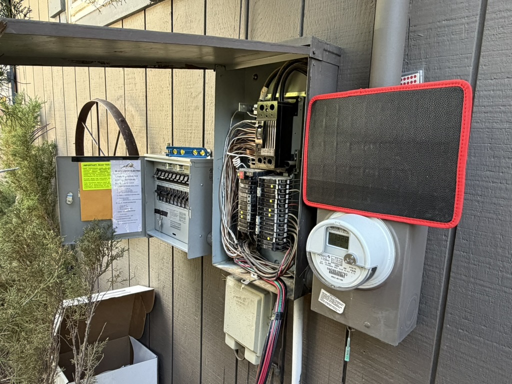 Outdoor electrical panel and adjacent transfer switch open during connection work