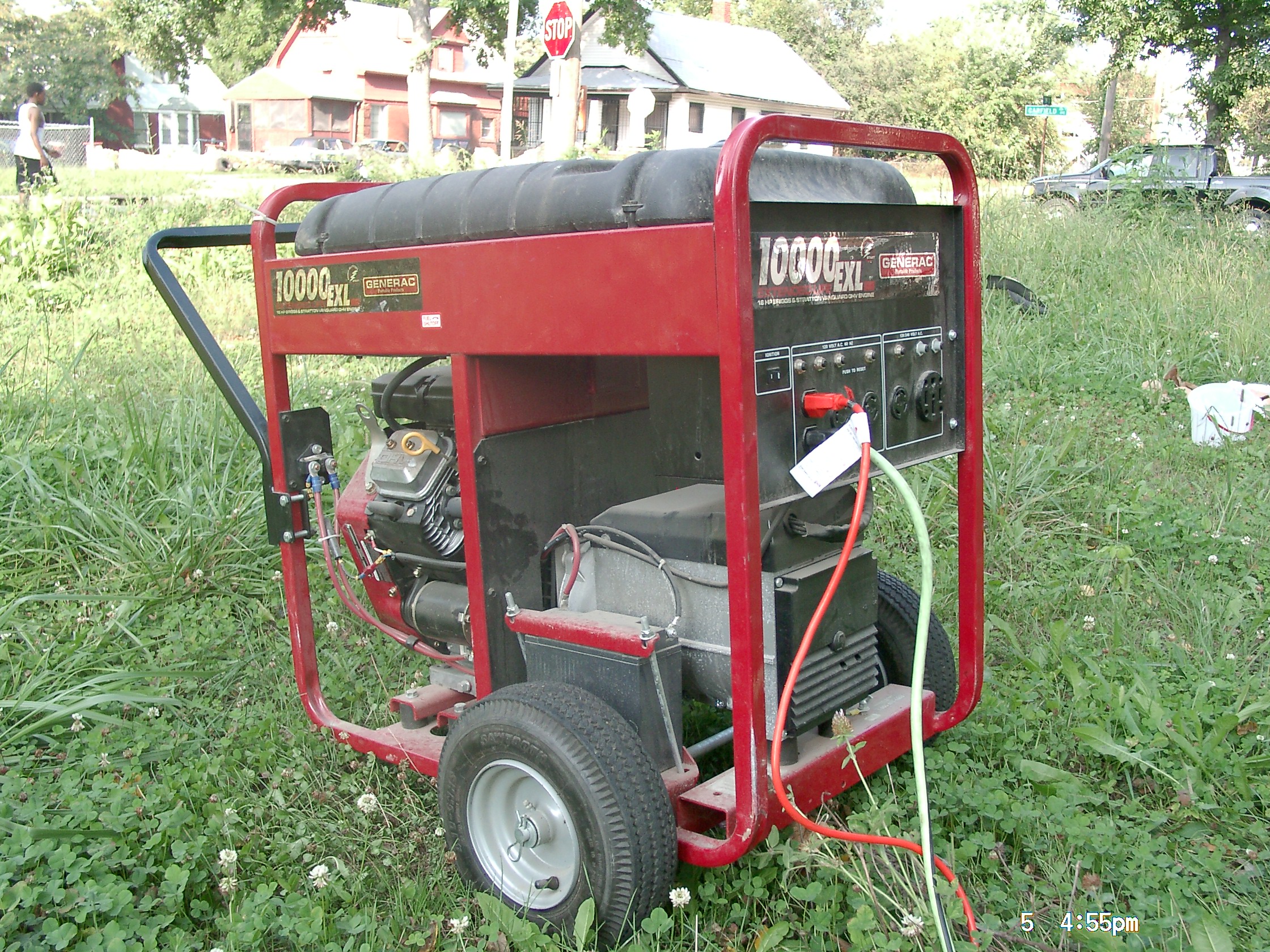 Wheeled portable generator outdoors on a grassy area.